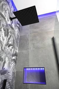 a room with a tile floor with a blue light at Davide Host LH89, 30min Duomo in Sesto San Giovanni