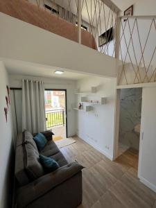 a living room with a couch and a staircase at Suite Sol Maragogi in São José da Coroa Grande