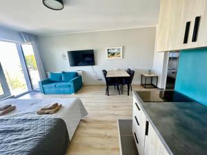 ein Schlafzimmer mit Bett und eine Küche mit Tisch in der Unterkunft Apartament Morza Szum in Sianożęty