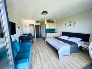 ein Schlafzimmer mit einem großen Bett und einem blauen Stuhl in der Unterkunft Apartament Morza Szum in Sianożęty + 28 Fotos
