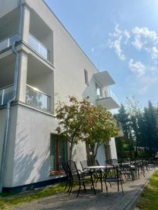 ein Gebäude mit Tischen und Stühlen davor in der Unterkunft Apartament Morza Szum in Sianożęty