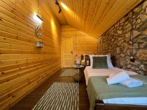 a bedroom with two beds in a log cabin at Villa Stone House in Kutaisi Heliport