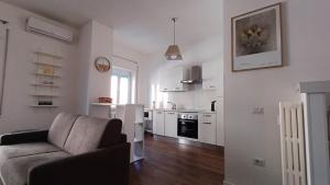 a living room with a couch and a kitchen at Casa Maricciotti in Terni