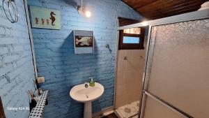 a bathroom with a sink and a shower at Casa rustica Ilhabela a 200 m da praia do Julião in Ilhabela