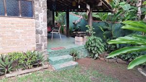 a porch of a house with a chair and a table at Casa rustica Ilhabela a 200 m da praia do Julião in Ilhabela