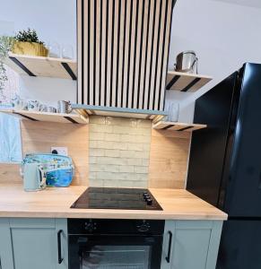 a kitchen with a stove and a black refrigerator at Luxury flat next to Blyth Port in Blythe +17 photos