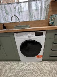 a washing machine under a counter in a kitchen at Luxury flat next to Blyth Port in Blythe