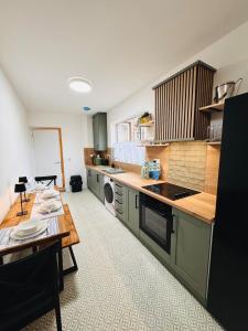 a kitchen with green cabinets and a table in it at Luxury flat next to Blyth Port in Blythe