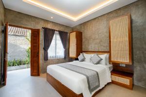 a bedroom with a large white bed and a window at Anadolu Ubud in Ubud