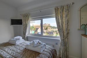 a bedroom with towels on a bed and a window at Finn Cottage in Bamburgh
