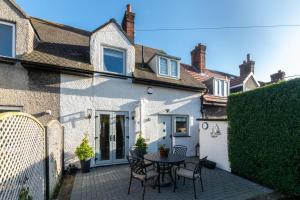 a patio with a table and chairs in front of a house at Finn Cottage in Bamburgh