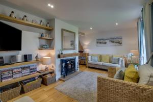a living room with a fireplace and a tv at Finn Cottage in Bamburgh