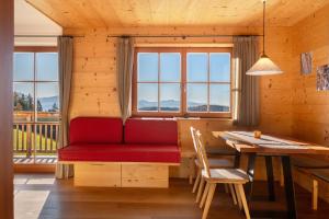 un salon avec un canapé rouge et une table dans l'établissement Oberfahrerhof Jenesien, à Meltina