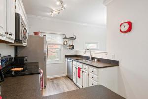 eine Küche mit Spüle und einer Uhr an der Wand in der Unterkunft Mass Ave Gem and steps away from Yoga Studio in Indianapolis + 28 Fotos