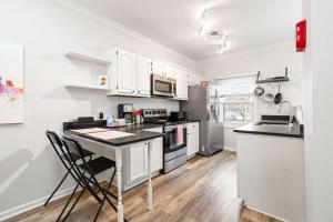 eine Küche mit weißen Schränken und einer schwarzen Arbeitsplatte in der Unterkunft Mass Ave Gem and steps away from Yoga Studio in Indianapolis