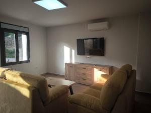 a living room with two chairs and a flat screen tv at El Limonero de Alajar in Alájar
