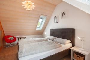 a bedroom with a bed and a red chair at Ferienwohnung Hinz in Todtnau