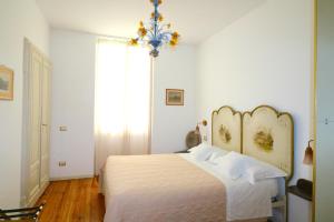 a bedroom with a white bed and a chandelier at Casa Elli Serbelloni 12 in Bellagio