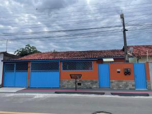 a building with blue and orange doors on a street at Aconchegante Kitnet na sede Aracruz 1 km do centro individual ótima logística lugar tranquilo in Aracruz