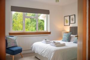 a bedroom with a bed and a window and a chair at Lawhead Road East in St. Andrews