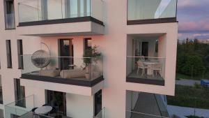 biały budynek z balkonem ze stołem w obiekcie Centaurus Olsztyn Sunset Apartament - Dwa Balkony & Darmowy Parking podziemny & Stare Miasto & Galeria & Widok & Planetarium & Centrum miasta w Olsztynie