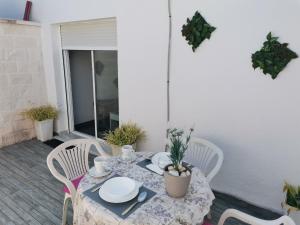 a table and chairs on a patio with a table and plates at Casasjerezanas Loft Las Flores in Jerez de la Frontera +6 photos