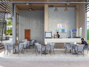 ein Restaurant mit Tischen und Stühlen und einer Theke in der Unterkunft Château Nude in Cebu City