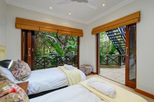 a bedroom with two beds and a balcony at San Lameer Villa 11703 - 5 Bedroom Luxury - 10 pax - San Lameer Rental Agency in Southbroom +62 photos