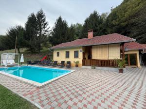 a house with a swimming pool in front of it at VILA LASOVIC + POOL + JACUZZI + SAUNA in Tuhelj