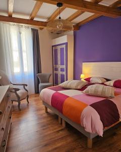 a bedroom with two beds and a purple wall at Les Cols du Ventoux - Appartement La Madeleine in Bédoin