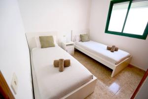 a bedroom with two beds with teddy bears on them at Casa Kalendra Rofe Tu refugio cerca del mar in Guatiza