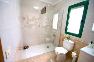 a bathroom with a toilet and a shower with a window at Casa Kalendra Rofe Tu refugio cerca del mar in Guatiza +31 photos