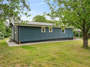 una casa azul con un árbol en el patio en Holiday Home Esme - 225m to the inlet by Interhome, en Holbæk