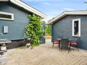 Un patio con una mesa y sillas al lado de un edificio. en Holiday Home Esme - 225m to the inlet by Interhome, en Holbæk