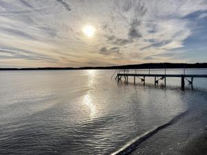 a dock on a body of water with the sun in the sky at Holiday Home Valia - 20m from the sea by Interhome in Sønder Stenderup
