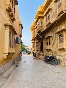 a motorcycle parked on a street next to buildings at Desert Cow Guesthouse - opp fort in Jaisalmer