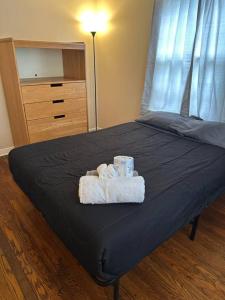 a bed with towels and a dresser in a bedroom at Quiet room near Rochester hospital in Irondequoit