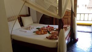 a bed in a room with towels on it at Double Heart Resort in Malindi +41 photos