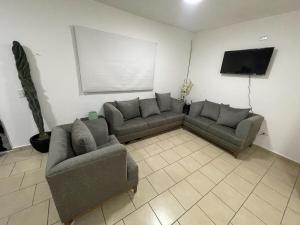 a living room with two couches and a flat screen tv at Casa el Castaño in Torreón