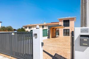 a fence in front of a house with a gate at Villetta Independente La Perla in Ceggia