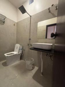 łazienka z umywalką, toaletą i lustrem w obiekcie Golden Vista Resort w mieście Krishnanagar