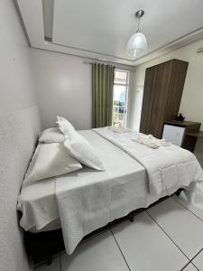 a white bed in a room with a window at Hotel Borari in Alter do Chao