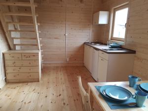 - une cuisine avec des murs en bois et une table dans une chambre dans l'établissement Bungalow in Miedzyzdroje near the Beach, à Międzyzdroje