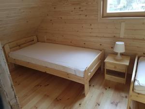 une chambre avec un lit dans une cabane en rondins dans l'établissement Bungalow in Miedzyzdroje near the Beach, à Międzyzdroje