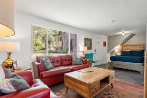 a living room with a red couch and a bed at Downtown Cozy Home Base - Purple Sage 6 in Moab