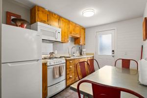 a kitchen with a white refrigerator and a table at Downtown Cozy Home Base - Purple Sage 6 in Moab