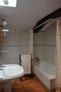 a bathroom with a white tub and a sink at Casa de Martiño in Friol