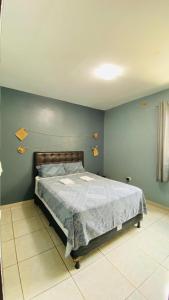 a bedroom with a bed with a blue wall at Aconchego na Capital do Forró in Caruaru +8 photos