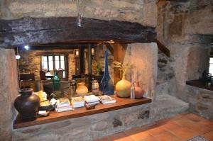 a stone fireplace with vases and books on it at Casa de Martiño in Friol +31 photos