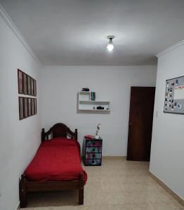 a bedroom with a red bed in a white room at Depto Tucumán in San Miguel de Tucumán